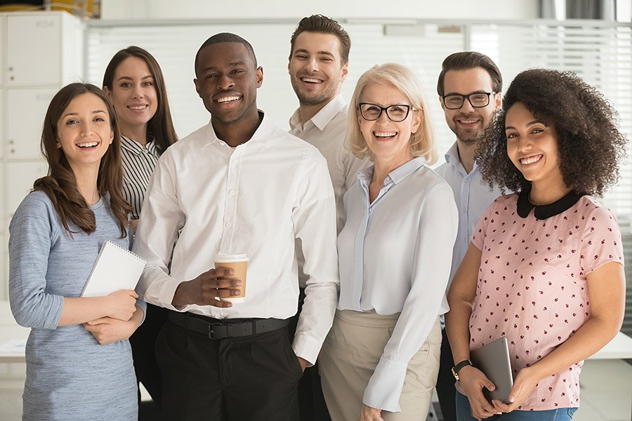 Positive multi racial corporate team posing looking at camera Positive multi racial corporate team posing looking at camera